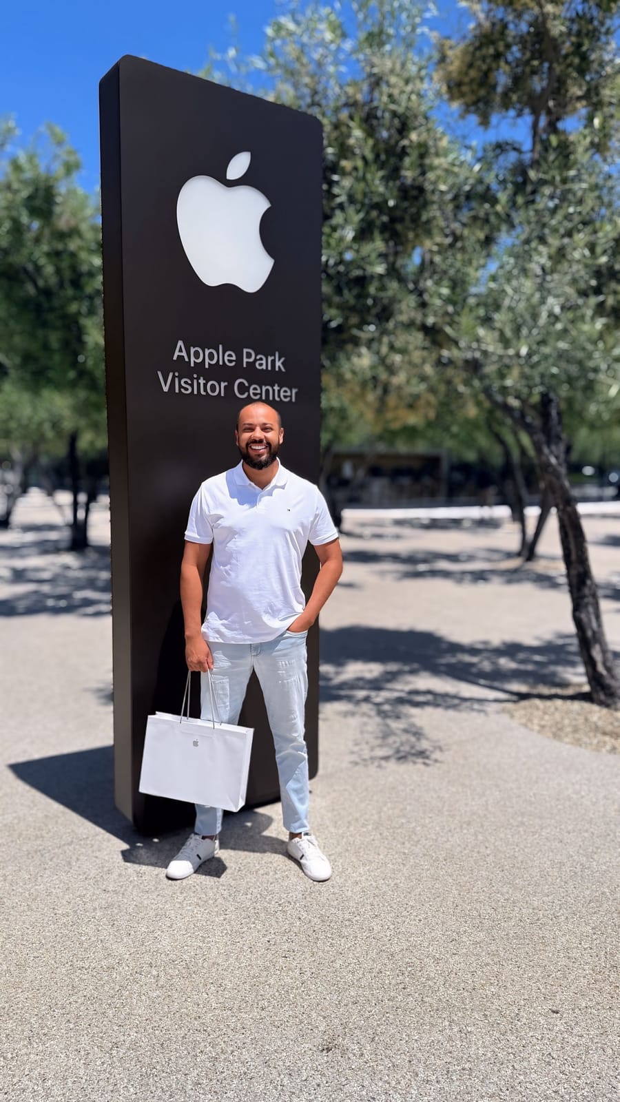 Gleidson Andrade em frente ao letreiro do Apple Park Visitor Center, sede da Apple em Cupertino, Califórnia